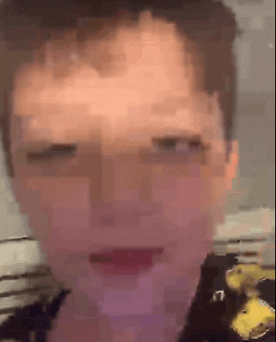 a close up of a person 's face with their eyes closed and a yellow shirt on .