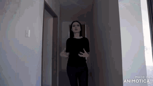 a woman in a black shirt stands in a hallway made in animatica