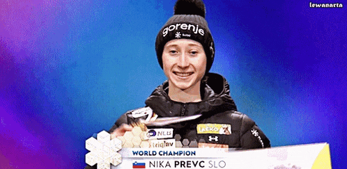 a woman wearing a gorenie hat is holding a medal