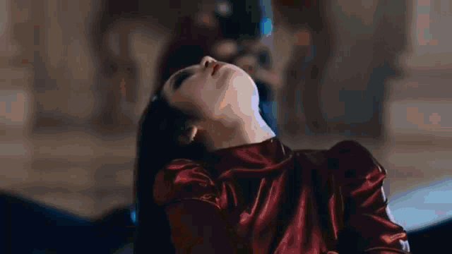 a woman in a red dress is laying on her back with her head up .