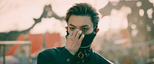 a young man wearing a black mask covering his face