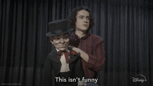 a man with a top hat is standing next to a puppet that says this isn 't funny