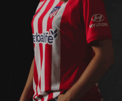 a woman is wearing a red and white striped shirt that says herbalife on the front