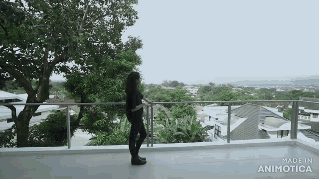 a woman standing on a balcony with the words made in animotica on the bottom right