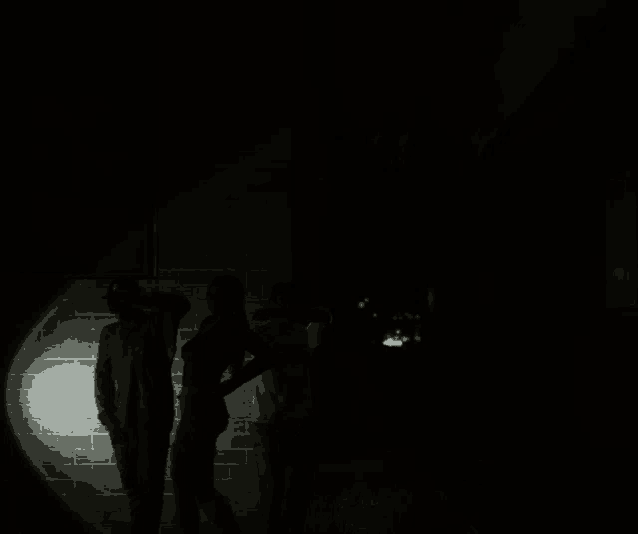 a group of people are standing in a dark room