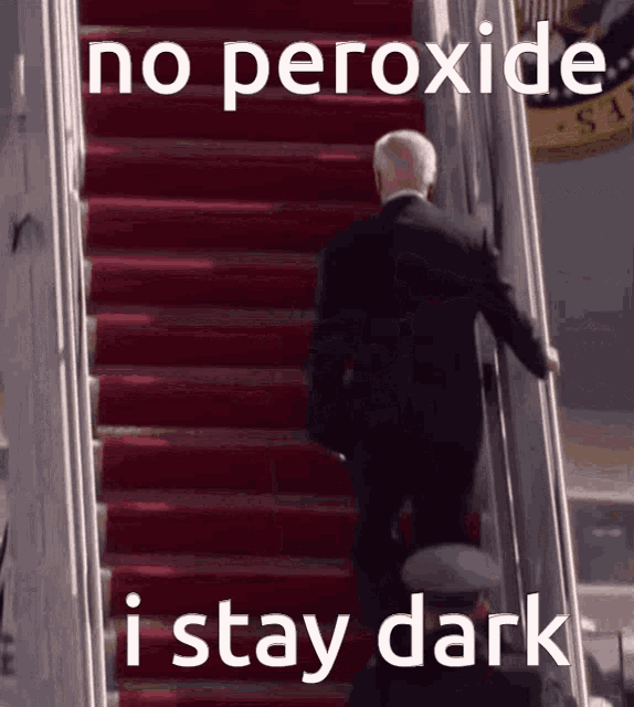 a man in a suit is walking up a set of red stairs with the words " no peroxide i stay dark "