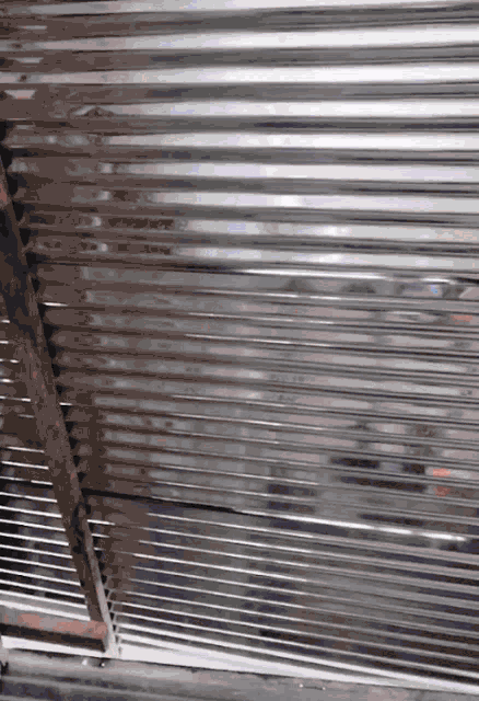 a close up of a metal fence with a few lines on it