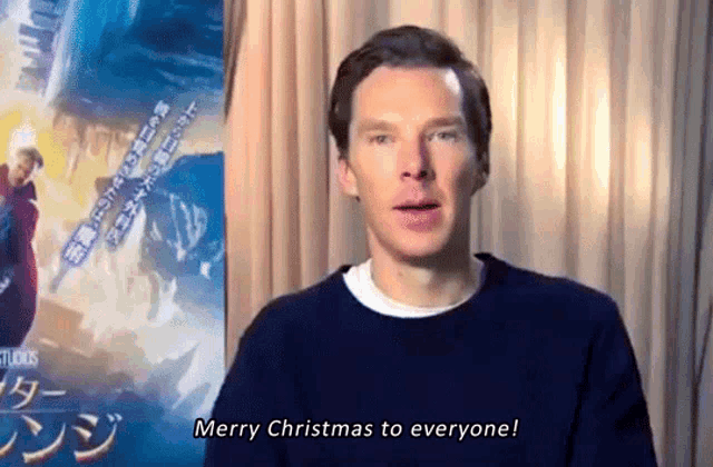a man says merry christmas to everyone in front of a poster