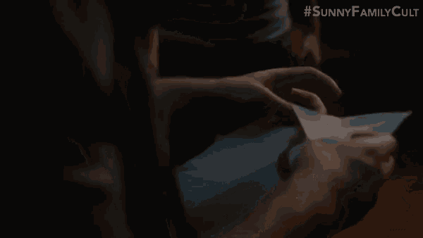 a person is holding a piece of paper with a bloody s on it .