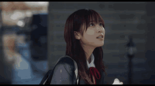 a girl in a school uniform is looking up
