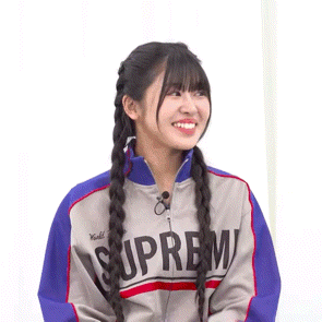 a girl wearing a jacket that says supreme is smiling