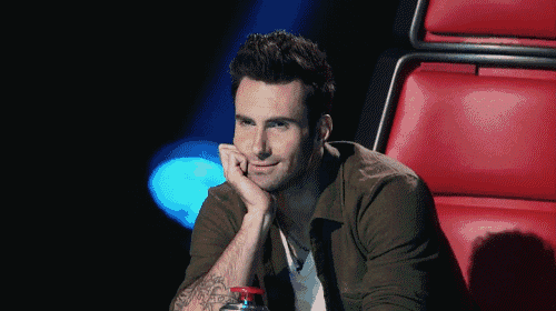 a man with a tattoo on his arm is sitting in a red chair