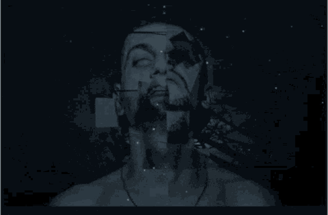 a man 's face is being projected on a dark wall