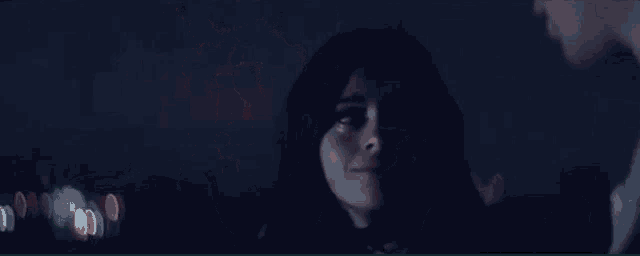 a woman is looking at a man in a dark room .
