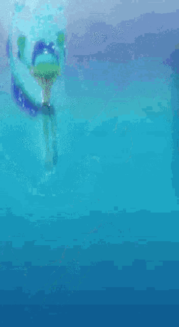 a person is swimming underwater in the ocean with bubbles coming out of it .