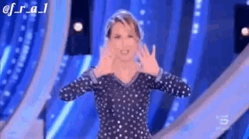 a woman in a polka dot dress is standing on a stage .