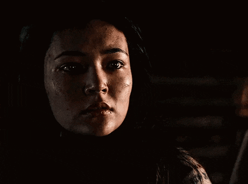 a close up of a woman 's face with a tear coming out of her eye