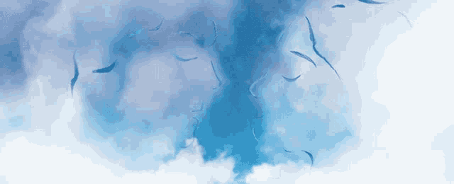 a blue sky with white clouds and a few birds flying in it