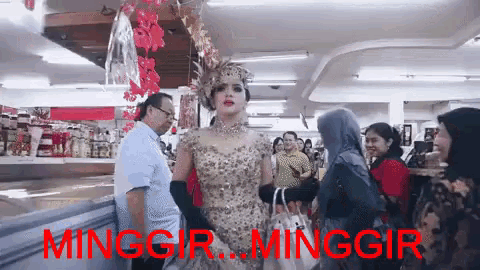 a woman in a wedding dress is standing in a crowd of people in a store with the words minggir minggir in red .