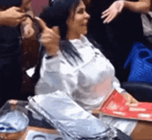 a woman is getting her hair done by a hairdresser in a salon .