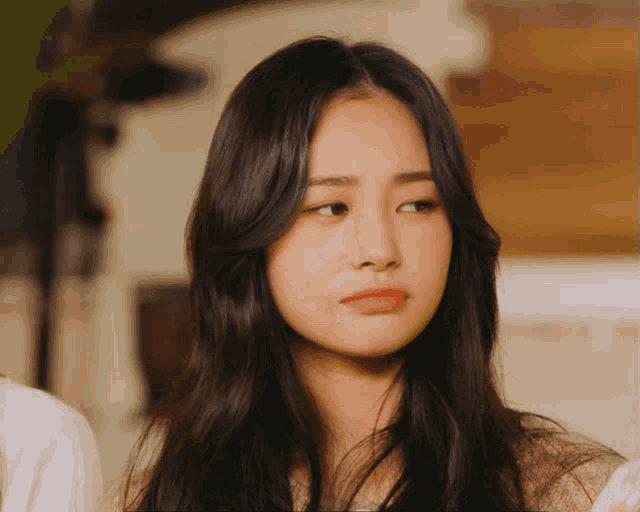 a woman with long dark hair looks at the camera