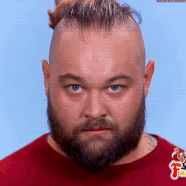a man with a beard is wearing a red shirt and has the letter f on his shirt