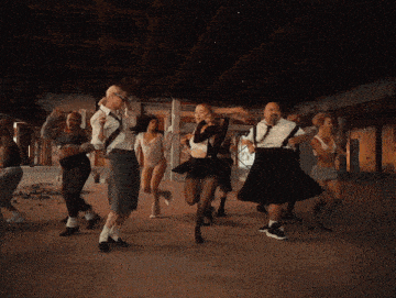 a group of men and women are dancing in a room