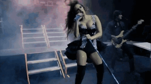 a woman singing into a microphone on a stage