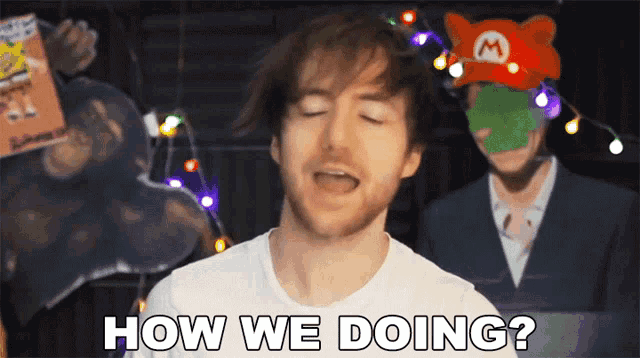 a man is asking how we doing in front of a mario hat