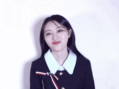 a woman in a black jacket with a white collar and red white and blue ribbon