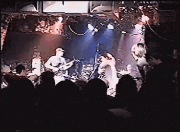 a group of people are playing instruments on a stage in a dark room .