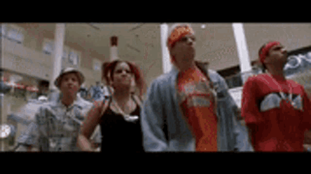 a group of people are standing next to each other in a shopping mall .