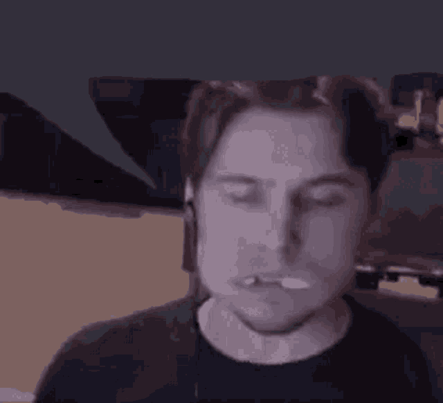 a man is smoking a cigarette and wearing headphones .