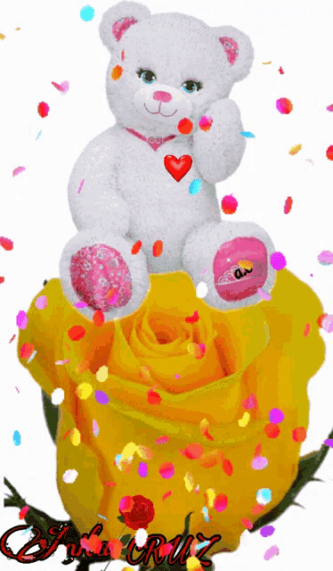 a teddy bear is sitting on a yellow rose