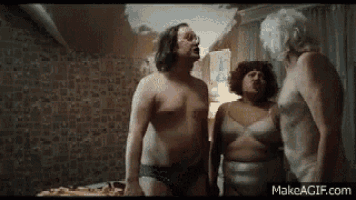 a man and two women are standing next to each other in a bedroom .