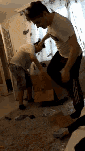 a man wearing a white shirt with the word adidas on it kicks another man