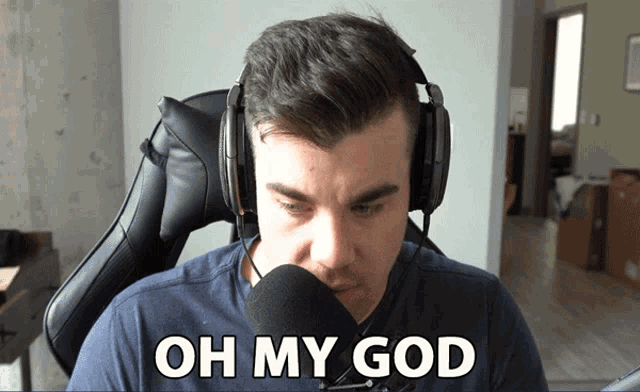 a man wearing headphones says " oh my god " in front of a microphone