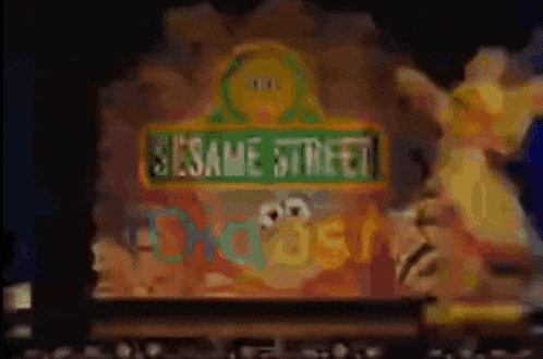 a sesame street sign with a statue of elmo in front of it