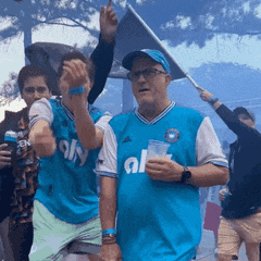 a man wearing a blue al jersey holds a cup