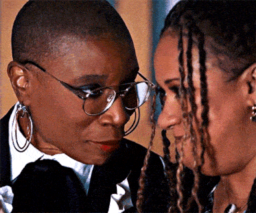 a close up of two women wearing glasses and earrings