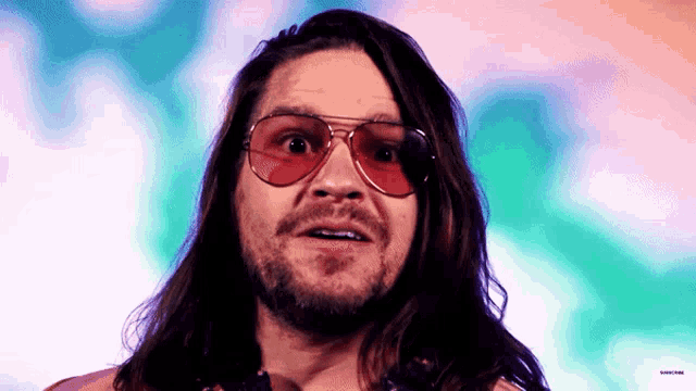 a man with long hair and a beard is wearing red sunglasses