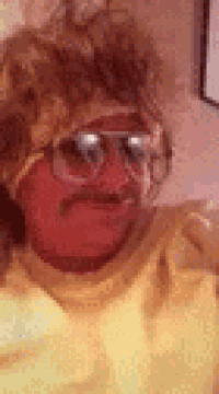 a man with glasses and a mustache is wearing a yellow shirt and a wig .