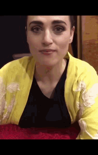 a woman wearing a black shirt and a yellow jacket