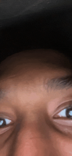 a close up of a person 's face with their eyes looking at the camera