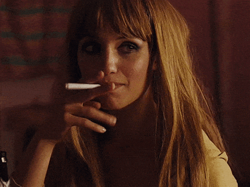 a woman with long hair is smoking a cigarette in her right hand