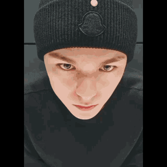 a close up of a person wearing a black beanie and a black shirt