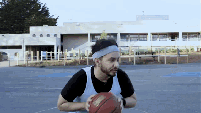 a man wearing a headband holds a basketball