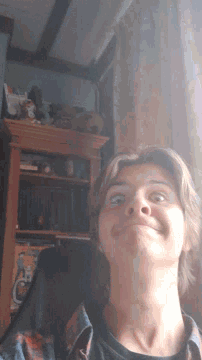 a man 's face is shown upside down in front of a bookshelf