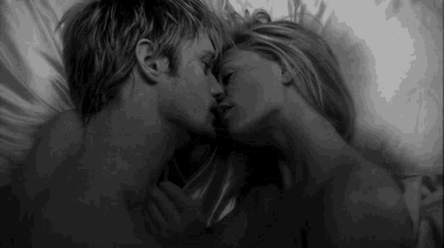 a man and a woman are kissing in bed