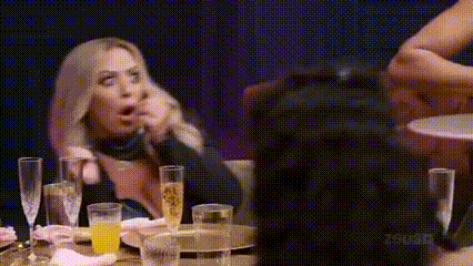 a woman is sitting at a table with glasses of champagne and a bottle of orange juice .